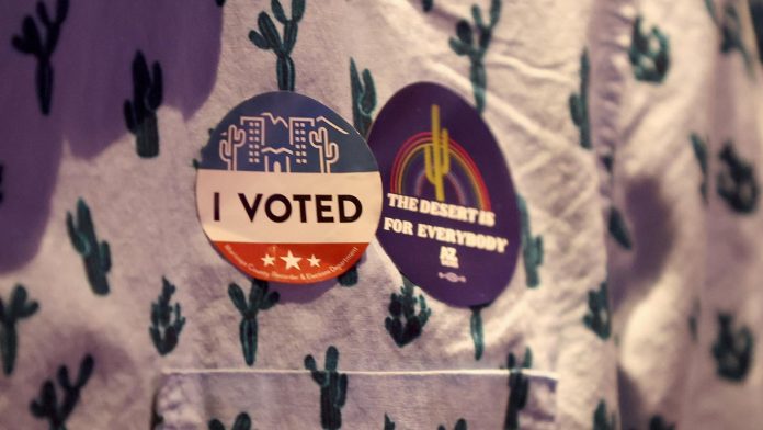 An attendee wears an "I Voted" sticker at a 2022 election night watch party in Phoenix....